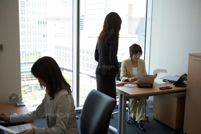 上司に書類を提出する女性 a の写真素材 イラスト素材 アマナイメージズ