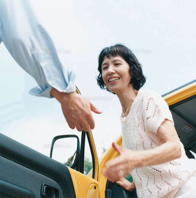 助手席から外に出る日本人中高年女性とエスコートする男性の手 の写真素材 イラスト素材 アマナイメージズ