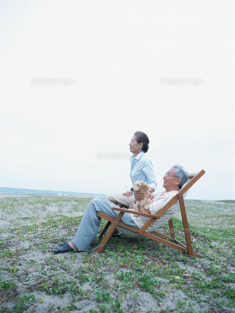 海岸でビーチチェアに座る中高年夫婦 日本人 の写真素材 イラスト素材 アマナイメージズ