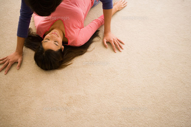 床に寝転がった女性と男性 の写真素材 イラスト素材 アマナイメージズ