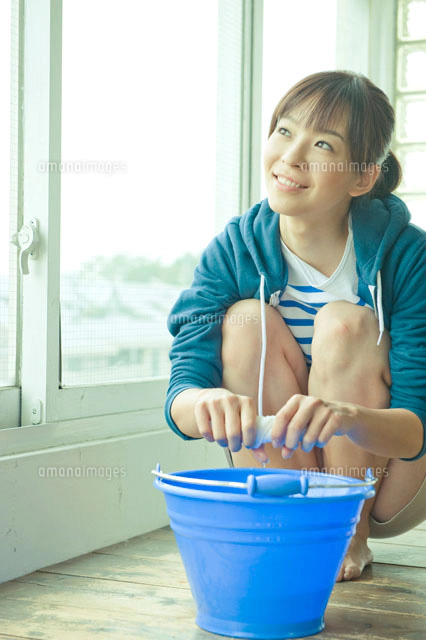 雑巾を絞りながら窓の外を見る女性 の写真素材 イラスト素材 アマナイメージズ