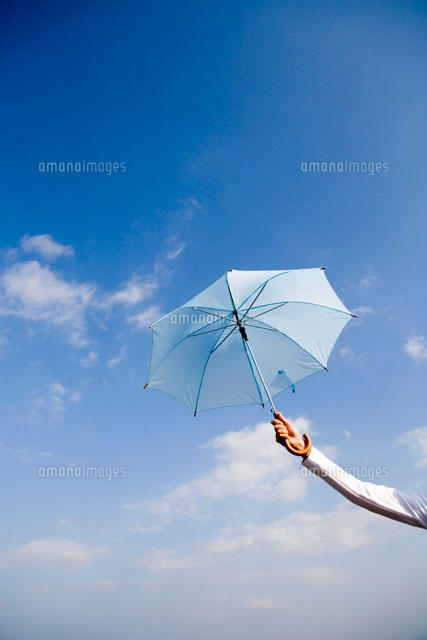 開いた傘を持った手と青空 の写真素材 イラスト素材 アマナイメージズ