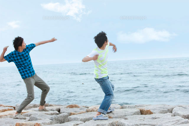 石を投げて遊ぶ男性2人 の写真素材 イラスト素材 アマナイメージズ