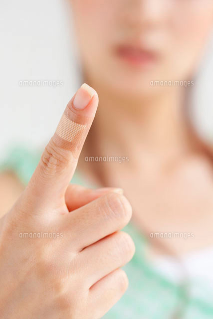 絆創膏を貼った女性の人差し指 の写真素材 イラスト素材 アマナイメージズ