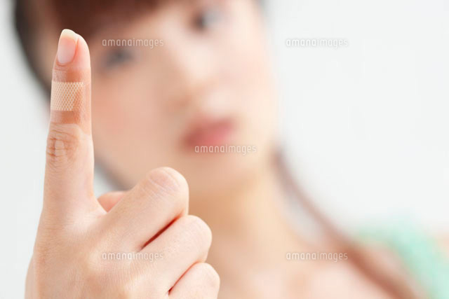 絆創膏を貼った女性の人差し指 の写真素材 イラスト素材 アマナイメージズ