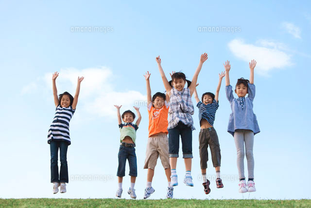 土手でジャンプする小学生 の写真素材 イラスト素材 アマナイメージズ
