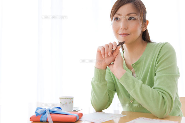 ペンを持って考える女性 の写真素材 イラスト素材 アマナイメージズ