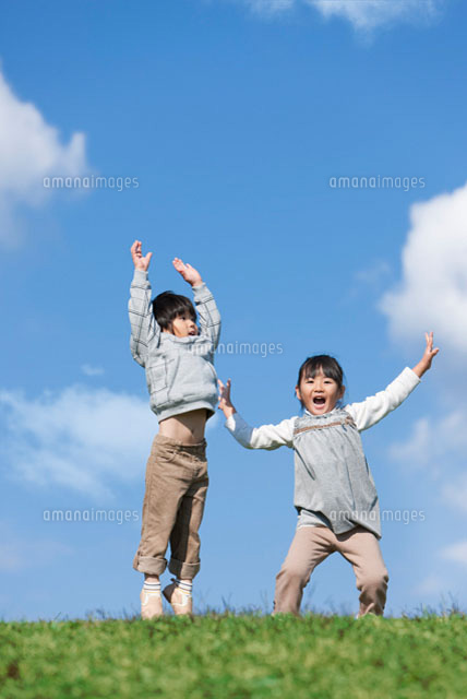 ジャンプしている笑顔の女の子と男の子 の写真素材 イラスト素材 アマナイメージズ
