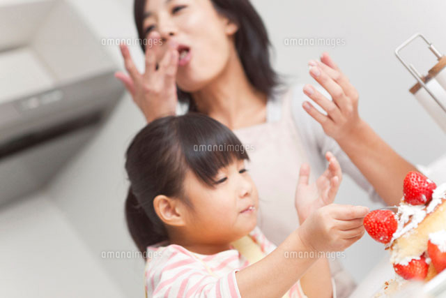 作ったケーキをつまみ食いする笑顔の親子 の写真素材 イラスト素材 アマナイメージズ