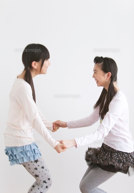 両手をつなぐ笑顔の女子中高生2人 の写真素材 イラスト素材 アマナイメージズ