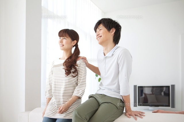 女性の肩に手を置く男性 の写真素材 イラスト素材 アマナイメージズ