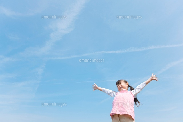 青空の下で手を広げている女の子 の写真素材 イラスト素材 アマナイメージズ