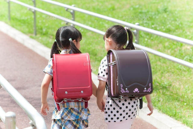 手をつないで歩く小学生の女の子2人の後姿 の写真素材 イラスト素材 アマナイメージズ