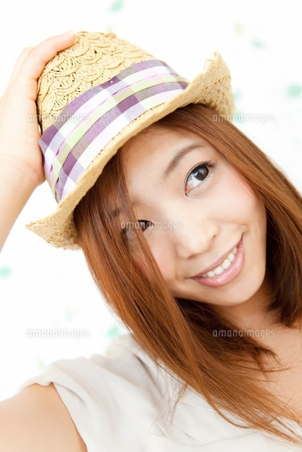 麦藁帽子を押さえる女性 の写真素材 イラスト素材 アマナイメージズ