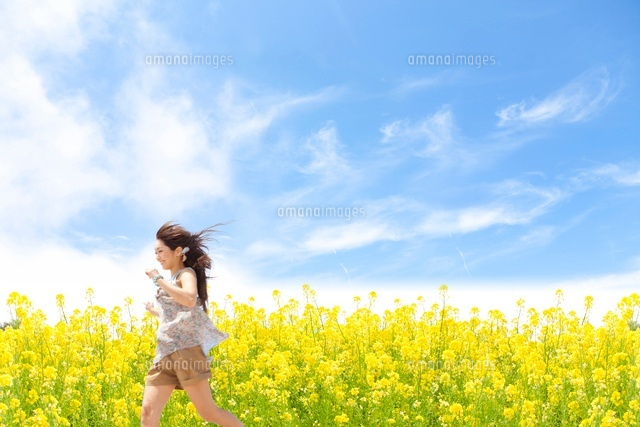 菜の花畑を駆け抜ける女性 の写真素材 イラスト素材 アマナイメージズ
