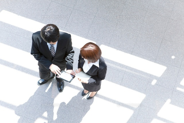 打合せするビジネスマンとビジネスウーマンの俯瞰 の写真素材 イラスト素材 アマナイメージズ