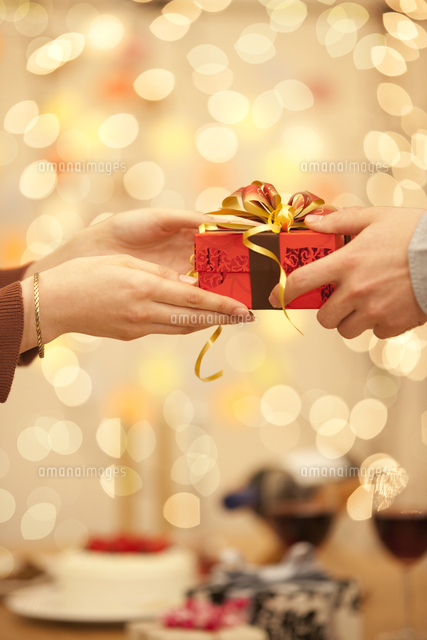 プレゼントを手渡す男女の手 の写真素材 イラスト素材 アマナイメージズ