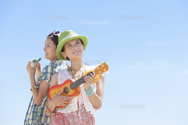 青空の下で楽器を演奏する女性2人 の写真素材 イラスト素材 アマナイメージズ