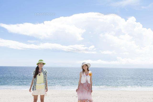 海岸に立っている笑顔の女性2人[07800039249]の写真・イラスト素材