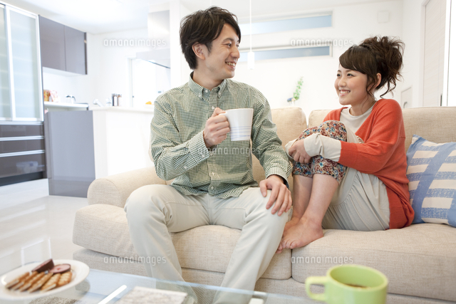 ソファーに座って話すカップル の写真素材 イラスト素材 アマナイメージズ