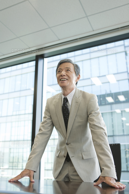 テーブルに手をつくビジネスマン の写真素材 イラスト素材 アマナイメージズ