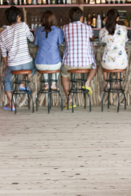 カウンターに座る後姿の男女 の写真素材 イラスト素材 アマナイメージズ