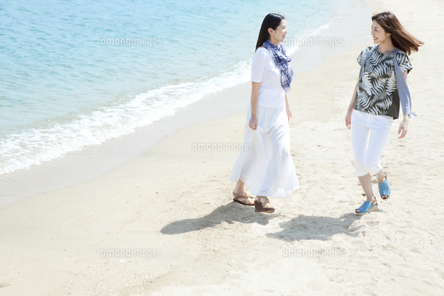 海辺を歩く女性2人 の写真素材 イラスト素材 アマナイメージズ