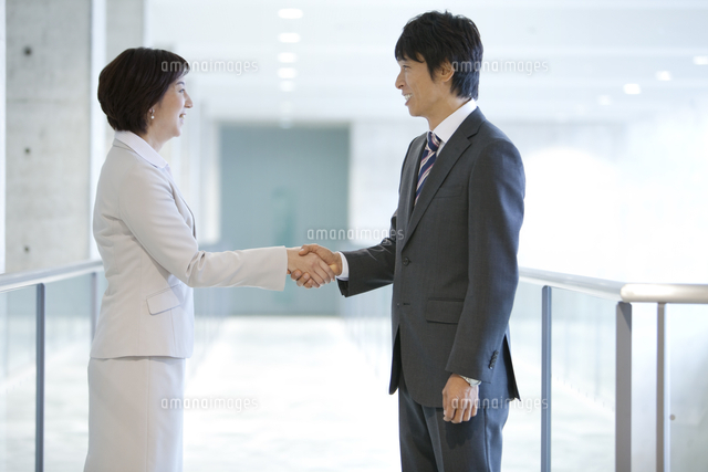 握手をするビジネスマンとビジネスウーマン の写真素材 イラスト素材 アマナイメージズ