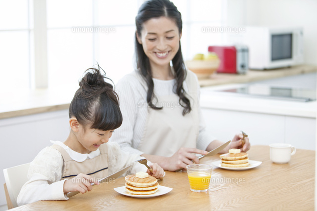 ホットケーキを食べる女の子と母親 の写真素材 イラスト素材 アマナイメージズ