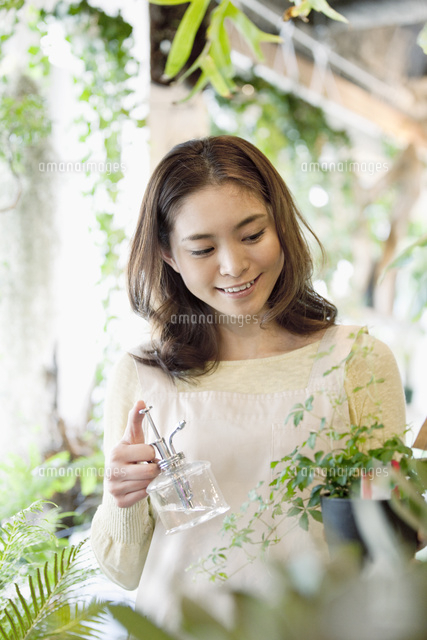 霧吹きを持つ女性店員 の写真素材 イラスト素材 アマナイメージズ