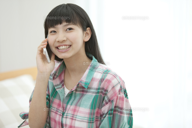 スマートフォンで通話する女の子 の写真素材 イラスト素材 アマナイメージズ
