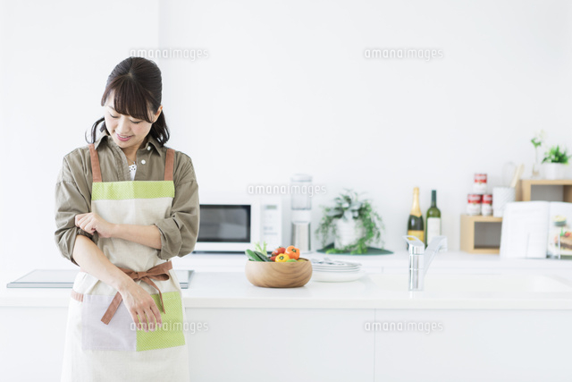 キッチンで腕まくりをする女性 の写真素材 イラスト素材 アマナイメージズ