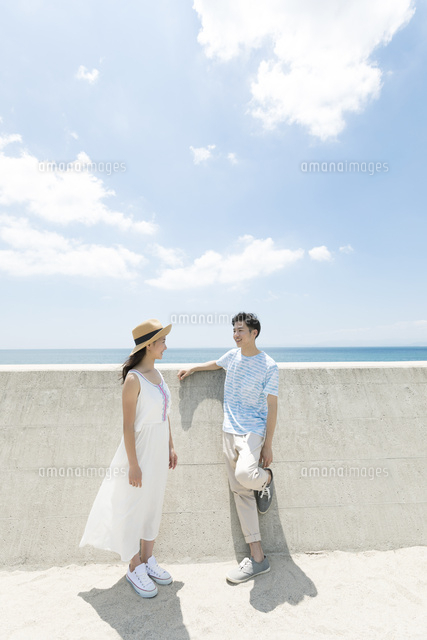 防波堤の前に立つカップル の写真素材 イラスト素材 アマナイメージズ