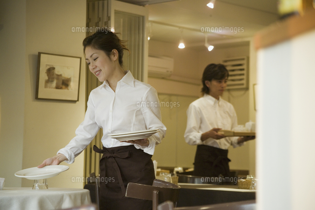 お皿を運ぶエプロン姿の女性と男性 の写真素材 イラスト素材 アマナイメージズ