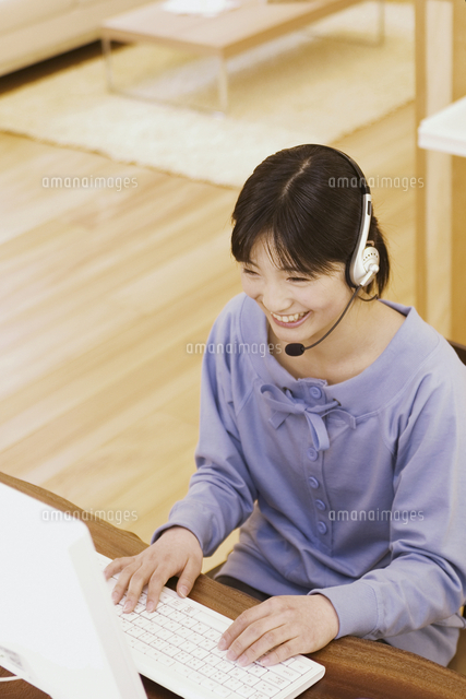 インカムをしてパソコンする女の子 の写真素材 イラスト素材 アマナイメージズ