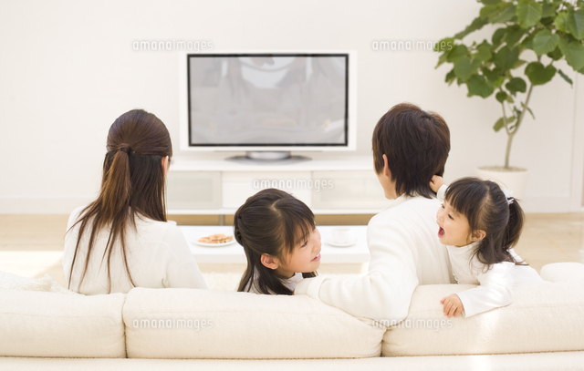 Tvを見る夫婦の後姿と遊ぶ姉妹 の写真素材 イラスト素材 アマナイメージズ