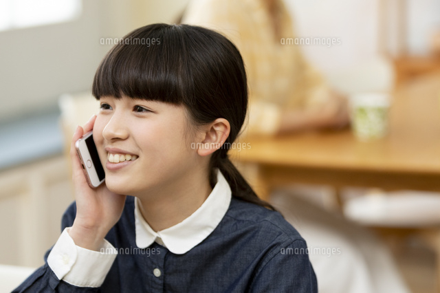 スマートフォンで電話する女の子 の写真素材 イラスト素材 アマナイメージズ