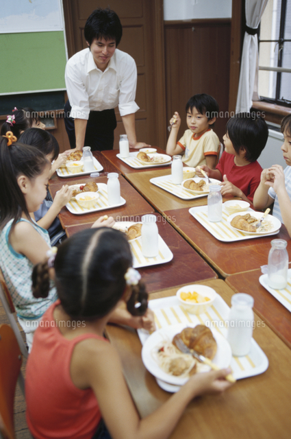 給食を食べる小学生と先生 の写真素材 イラスト素材 アマナイメージズ