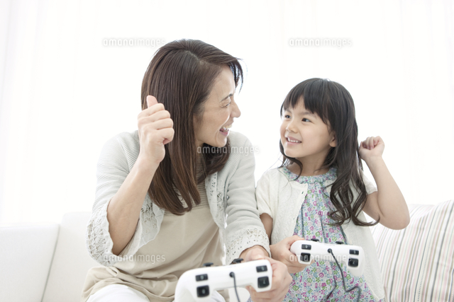 ゲームをする女の子と祖母 の写真素材 イラスト素材 アマナイメージズ