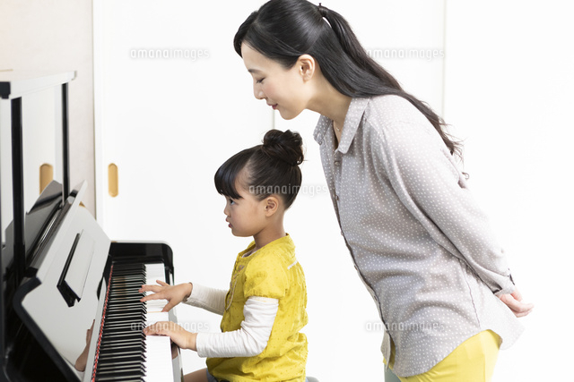 ピアノを弾く娘と見守る母親 の写真素材 イラスト素材 アマナイメージズ