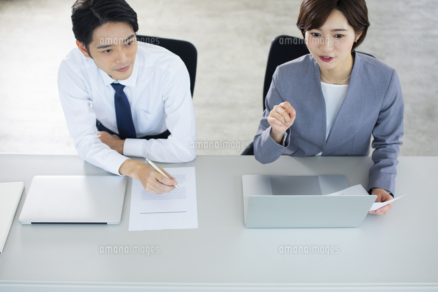 隣り合わせで座るビジネス男女 の写真素材 イラスト素材 アマナイメージズ