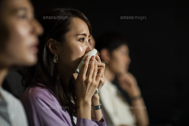 映画を観て涙をハンカチで拭う女性 の写真素材 イラスト素材 アマナイメージズ