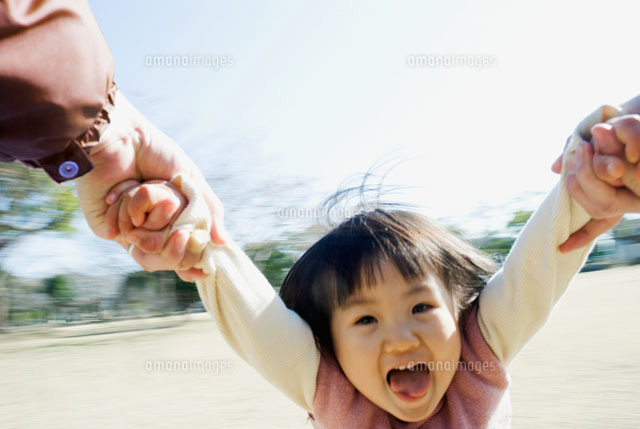 回転遊びで宙を舞う日本人の女の子の笑顔 の写真素材 イラスト素材 アマナイメージズ