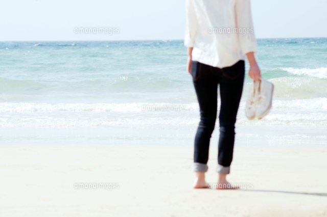 打ち寄せる波と靴を持った女性 の写真素材 イラスト素材 アマナイメージズ