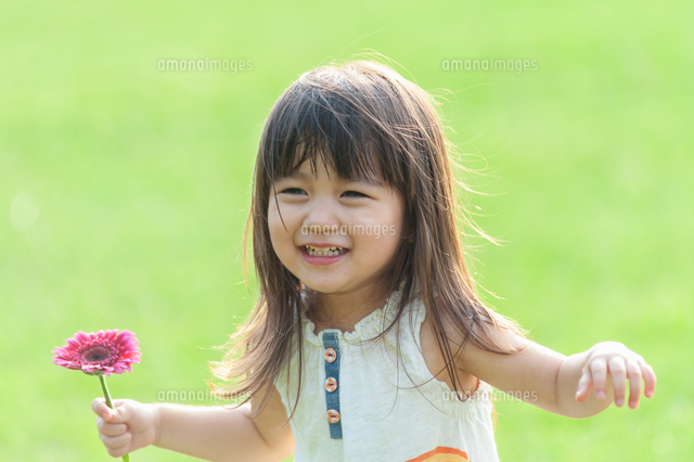 花を持って笑う女の子 の写真素材 イラスト素材 アマナイメージズ