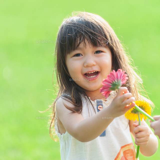 花を持って笑う女の子 の写真素材 イラスト素材 アマナイメージズ