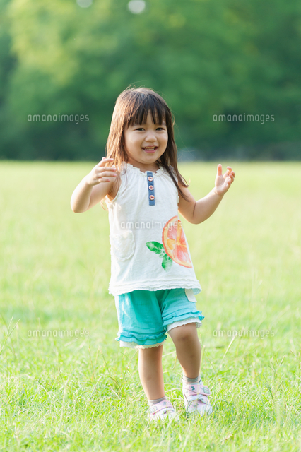 草原で踊りながら笑う女の子 の写真素材 イラスト素材 アマナイメージズ