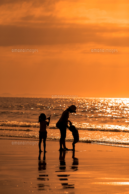 夕暮れの海辺で遊ぶ親子のシルエット の写真素材 イラスト素材 アマナイメージズ