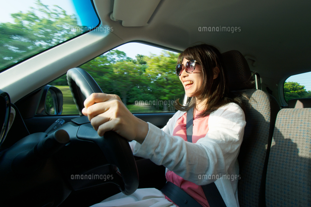 車を運転しながら楽しそうに歌う女性 の写真素材 イラスト素材 アマナイメージズ