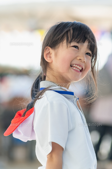 笑いながら見上げる体操服の園児[10112002984]の写真・イラスト素材